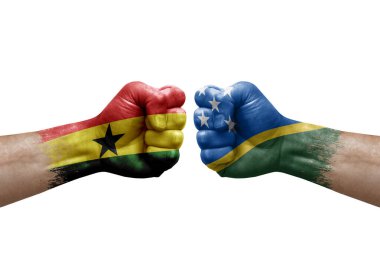 Two hands punch to each others on white background. Country flags painted fists, conflict crisis concept between ghana and solomon islands