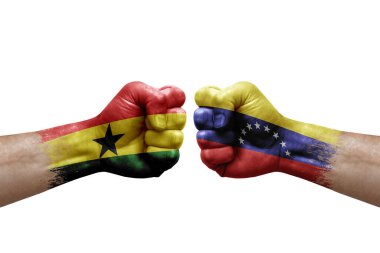 Two hands punch to each others on white background. Country flags painted fists, conflict crisis concept between ghana and venezuela