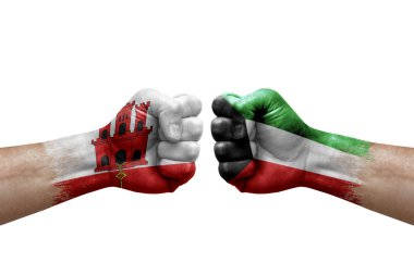 Two hands punch to each others on white background. Country flags painted fists, conflict crisis concept between gibraltar and kuwait