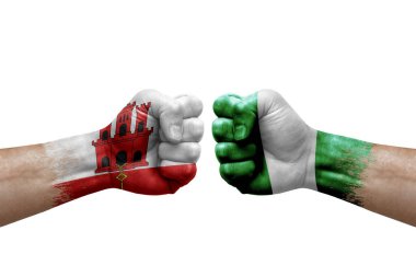 Two hands punch to each others on white background. Country flags painted fists, conflict crisis concept between gibraltar and nigeria