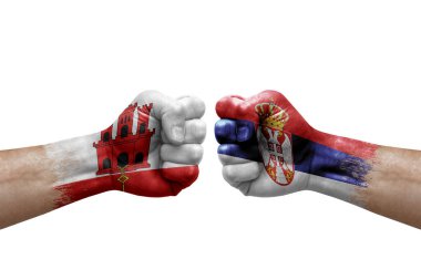 Two hands punch to each others on white background. Country flags painted fists, conflict crisis concept between gibraltar and serbia