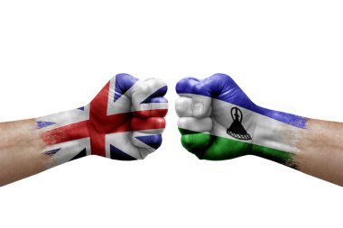 Two hands punch to each others on white background. Country flags painted fists, conflict crisis concept between great britain and lesotho