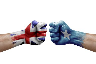 Two hands punch to each others on white background. Country flags painted fists, conflict crisis concept between great britain and somalia