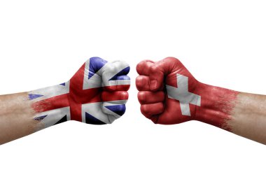 Two hands punch to each others on white background. Country flags painted fists, conflict crisis concept between great britain and switzerland