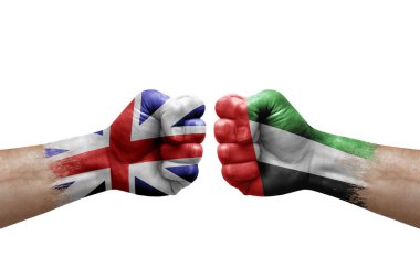 Two hands punch to each others on white background. Country flags painted fists, conflict crisis concept between great britain and united arab emirates