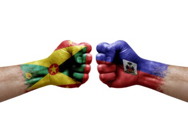 Two hands punch to each others on white background. Country flags painted fists, conflict crisis concept between grenada and haiti