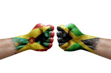 Two hands punch to each others on white background. Country flags painted fists, conflict crisis concept between grenada and jamaica