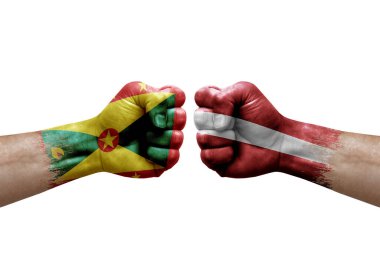 Two hands punch to each others on white background. Country flags painted fists, conflict crisis concept between grenada and latvia