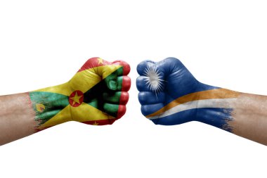 Two hands punch to each others on white background. Country flags painted fists, conflict crisis concept between grenada and marshall islands