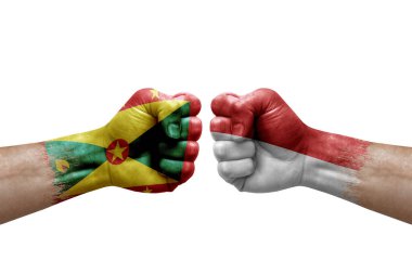 Two hands punch to each others on white background. Country flags painted fists, conflict crisis concept between grenada and monaco