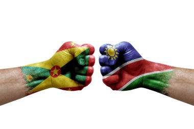 Two hands punch to each others on white background. Country flags painted fists, conflict crisis concept between grenada and namibia