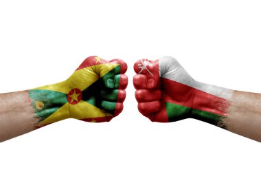 Two hands punch to each others on white background. Country flags painted fists, conflict crisis concept between grenada and oman