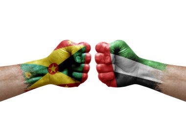 Two hands punch to each others on white background. Country flags painted fists, conflict crisis concept between grenada and united arab emirates