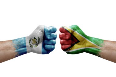 Two hands punch to each others on white background. Country flags painted fists, conflict crisis concept between guatemala and guyana