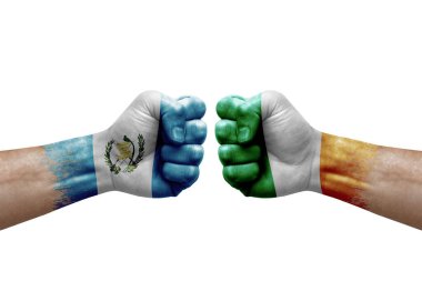 Two hands punch to each others on white background. Country flags painted fists, conflict crisis concept between guatemala and ireland