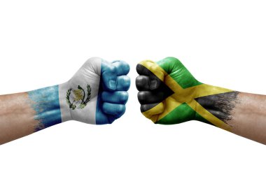 Two hands punch to each others on white background. Country flags painted fists, conflict crisis concept between guatemala and jamaica