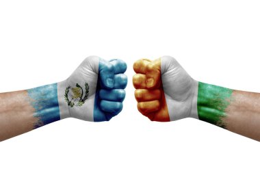 Two hands punch to each others on white background. Country flags painted fists, conflict crisis concept between guatemala and ivory coast