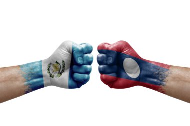 Two hands punch to each others on white background. Country flags painted fists, conflict crisis concept between guatemala and laos