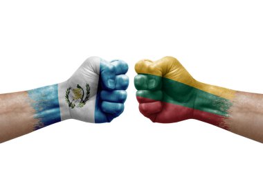 Two hands punch to each others on white background. Country flags painted fists, conflict crisis concept between guatemala and lithuania