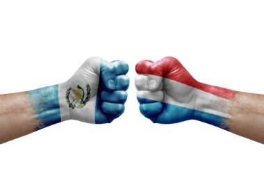Two hands punch to each others on white background. Country flags painted fists, conflict crisis concept between guatemala and luxembourg