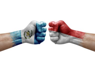 Two hands punch to each others on white background. Country flags painted fists, conflict crisis concept between guatemala and monaco