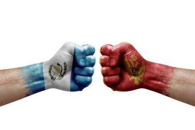 Two hands punch to each others on white background. Country flags painted fists, conflict crisis concept between guatemala and montenegro