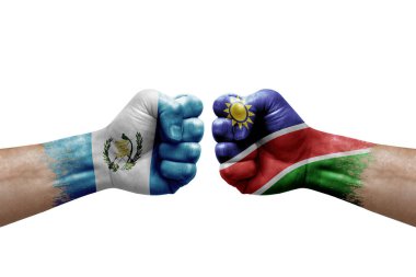 Two hands punch to each others on white background. Country flags painted fists, conflict crisis concept between guatemala and namibia