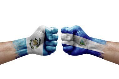 Two hands punch to each others on white background. Country flags painted fists, conflict crisis concept between guatemala and nicaragua