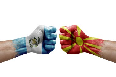 Two hands punch to each others on white background. Country flags painted fists, conflict crisis concept between guatemala and north macedonia