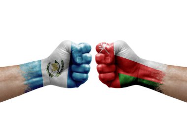 Two hands punch to each others on white background. Country flags painted fists, conflict crisis concept between guatemala and oman