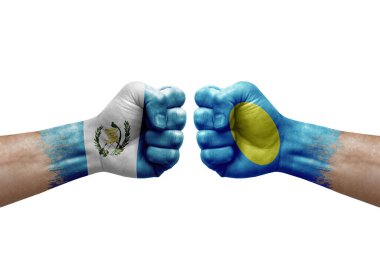 Two hands punch to each others on white background. Country flags painted fists, conflict crisis concept between guatemala and palau