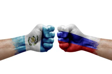 Two hands punch to each others on white background. Country flags painted fists, conflict crisis concept between guatemala and russia