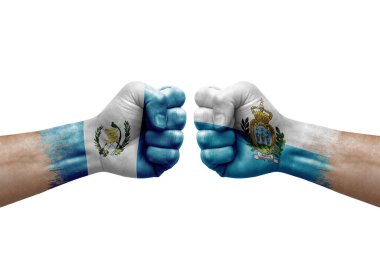 Two hands punch to each others on white background. Country flags painted fists, conflict crisis concept between guatemala and san marino