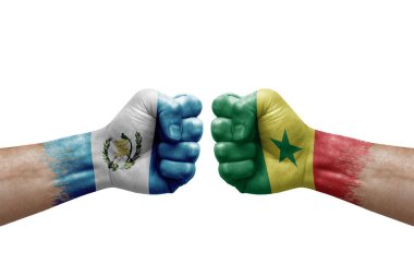 Two hands punch to each others on white background. Country flags painted fists, conflict crisis concept between guatemala and senegal