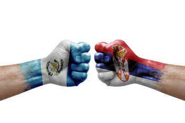 Two hands punch to each others on white background. Country flags painted fists, conflict crisis concept between guatemala and serbia