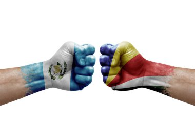 Two hands punch to each others on white background. Country flags painted fists, conflict crisis concept between guatemala and seychelles