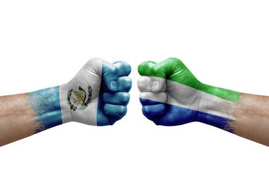 Two hands punch to each others on white background. Country flags painted fists, conflict crisis concept between guatemala and sierra leone
