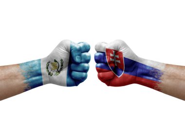 Two hands punch to each others on white background. Country flags painted fists, conflict crisis concept between guatemala and slovakia