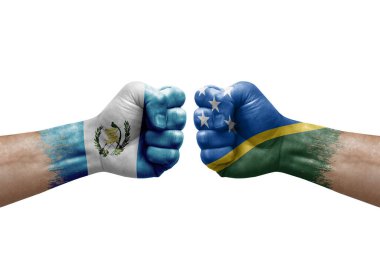 Two hands punch to each others on white background. Country flags painted fists, conflict crisis concept between guatemala and solomon islands