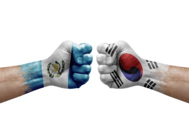 Two hands punch to each others on white background. Country flags painted fists, conflict crisis concept between guatemala and south korea