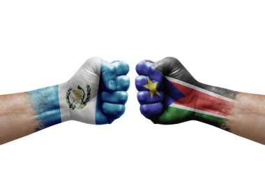 Two hands punch to each others on white background. Country flags painted fists, conflict crisis concept between guatemala and south sudan