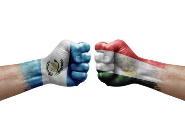 Two hands punch to each others on white background. Country flags painted fists, conflict crisis concept between guatemala and tajikistan