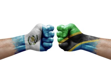 Two hands punch to each others on white background. Country flags painted fists, conflict crisis concept between guatemala and tanzania