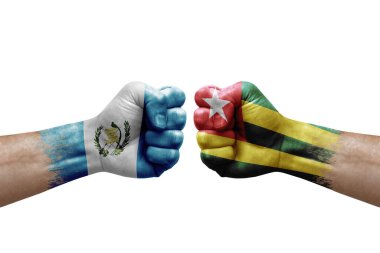 Two hands punch to each others on white background. Country flags painted fists, conflict crisis concept between guatemala and togo