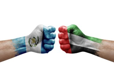 Two hands punch to each others on white background. Country flags painted fists, conflict crisis concept between guatemala and united arab emirates
