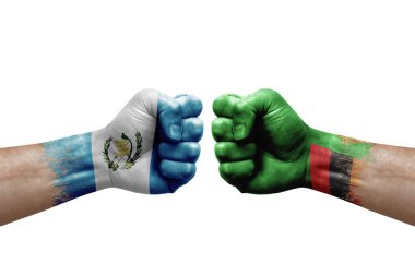 Two hands punch to each others on white background. Country flags painted fists, conflict crisis concept between guatemala and zambia