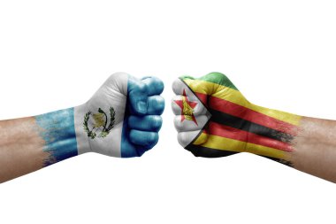 Two hands punch to each others on white background. Country flags painted fists, conflict crisis concept between guatemala and zimbabwe