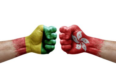 Two hands punch to each others on white background. Country flags painted fists, conflict crisis concept between guinea and hong kong