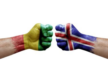 Two hands punch to each others on white background. Country flags painted fists, conflict crisis concept between guinea and iceland