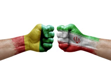 Two hands punch to each others on white background. Country flags painted fists, conflict crisis concept between guinea and iran